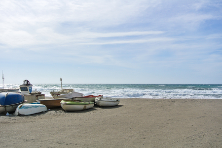 CABO DE GATA, SPAIN - FEBRUARY 9, 2016: Fishing boats at the shore of national park Cabo de Gata near Almeria (Andalusia, Spain) and sea waves on the background.のeditorial素材