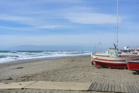 CABO DE GATA, SPAIN - FEBRUARY 9, 2016: Fishing boats at the shore of national park Cabo de Gata near Almeria (Andalusia, Spain) and sea waves on the background.のeditorial素材
