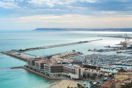 ALICANTE, SPAIN - FEBRUARY 12, 2016: A view from Santa Barbara Castle to a port of the city with a plenty of yachts, to roofs of the buildings and to Mediterranean sea on cloudy day, Alicante, Spain.のeditorial素材