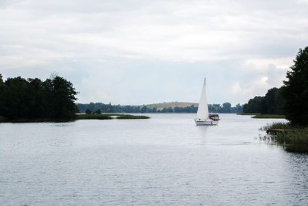 A lonely sailing boat at the lake near Trakai castle on rainy summer day, Lithuania.のeditorial素材