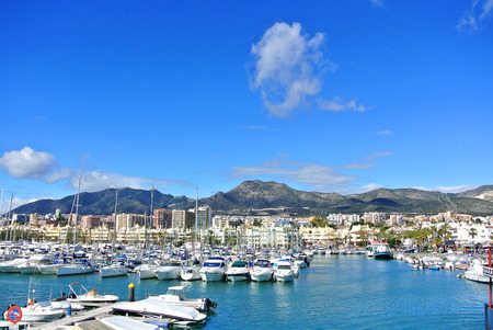 BENALMADENA, SPAIN - FEBRUARY 13, 2014: Benalmadena Marina port, a view to piers with yachts, Mediterranean sea and mountains at the background.のeditorial素材