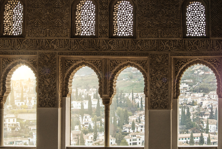 GRANADA, SPAIN - FEBRUARY 10, 2015: A view to old white houses of Granada through a window decorated with calligraphy and oriental ornaments, palace of Alhambra, Granada, Andalusia, Spain.のeditorial素材