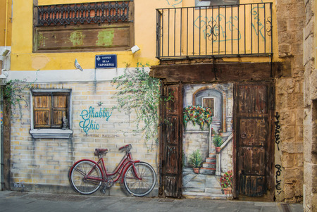 VALENCIA, SPAIN - FEBRUARY 3, 2016: Graffity with a bicycle and an old door at the street of old town of Valencia city, Costa Blanca, Spain.のeditorial素材