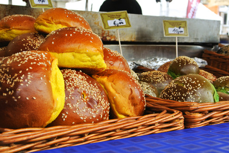 FRANKFURT, GERMANY - JUNE 6, 2017: A set of fresh burger buns of different color with sesame seeds in the baskets prepared for cooking at the street farm market, Frankfurt am Main, Germany.のeditorial素材