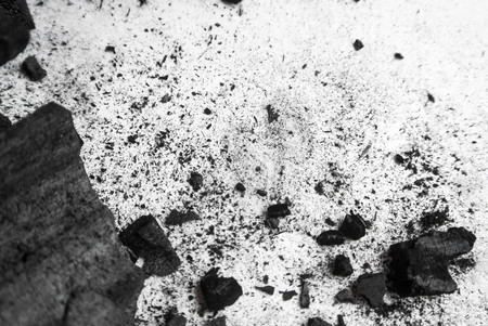 Black abstract textured composition on a white background, a selected focus close-up of a pile of cubes and powder of black mineral coal.の写真素材