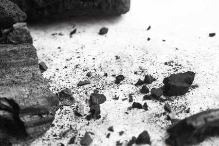Black abstract textured composition on a white background, a selected focus close-up of a pile of cubes and powder of black mineral coal.の写真素材