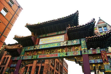MANCHESTER, ENGLAND - AUGUST 11, 2013: China Town gate with green and golden decoration and painted panels at Manchester city center, one of the lagest in the UK and Europe.のeditorial素材