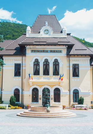 SINAIA, ROMANIA - JULY 30, 2017: A view to beautiful  decorated administrative building of Primaria Sinaia with flags and a fontain in front of it.のeditorial素材