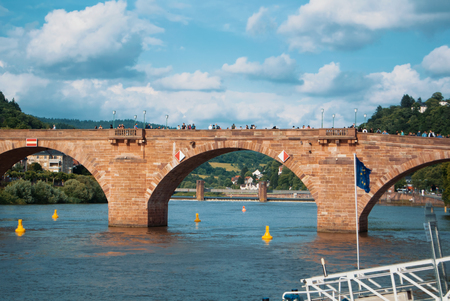 HEIDELBERG, GERMANY - JUNE 4, 2017: Carl Theodor bridge and Nekkar river embankment with many houses and a hill at the background on sunny summer evening, Heidelberg, Germany.のeditorial素材