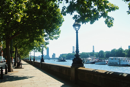 LONDON, ENGLAND - AUGUST 01, 2013: Riverside promenade of South Bank of Thames river in London under big green trees on sunny summer day.のeditorial素材