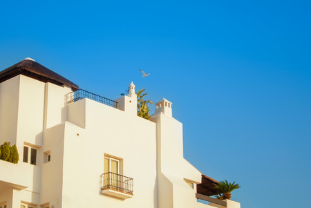 TORREMOLINOS, SPAIN - FEBRUARY 15, 2014:  A close-up view to detalles of beautiful white decorated building of a hotel in Torremolinos and a flying seagull. Copy space for text.のeditorial素材