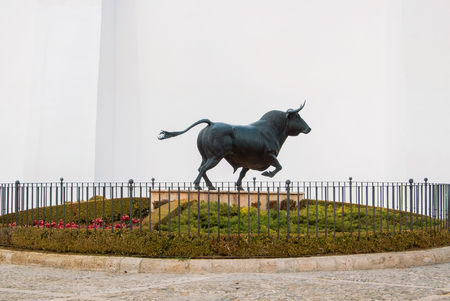 RONDA, SPAIN - FEBRUARY 03, 2014: A statue monument figure of a big black fighting running bull near a Bullring of Ronda (Plaza de Toros), the oldest bullring of Spain, Malaga province, Andalusia.のeditorial素材