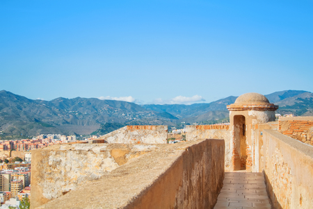 A view to the city and its surroundings with mountains at the background from old medieval walls of the Gibralfaro Castle of Malaga, Andalusia, Spain, on sunny evening.の写真素材