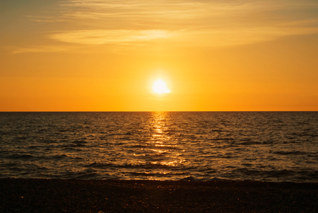 A beautiful bright colorful seascape with setting sun, colorful evening twilight landscape, abstract background of holiday relaxing vacation by the sea.の写真素材