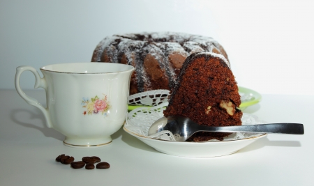 Piece of chocolate cake, a cup of coffee and coffee beansの写真素材