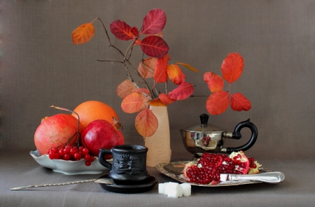 Cup of coffee,pomegranate divided into parts and autumn leaves in a vaseの写真素材