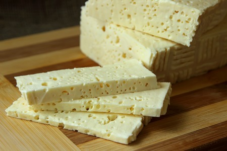 Home cheese, cut into pieces on the board and knife
の写真素材