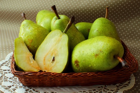 Green pears in a basket and one of them cut into the share
の写真素材