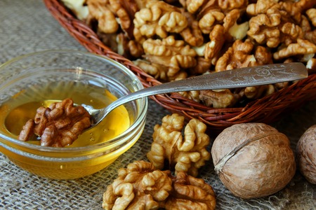 Plate with a spoon of honey and shelled walnutsの写真素材