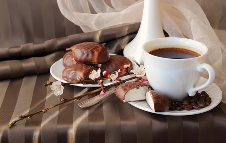 A cup of coffee, a branch of apricot and marshmallowsの写真素材