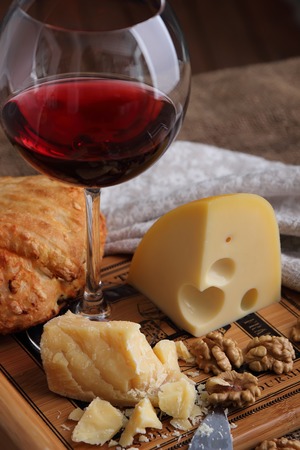 A glass of wine, hard, aged cheese and nuts.の写真素材