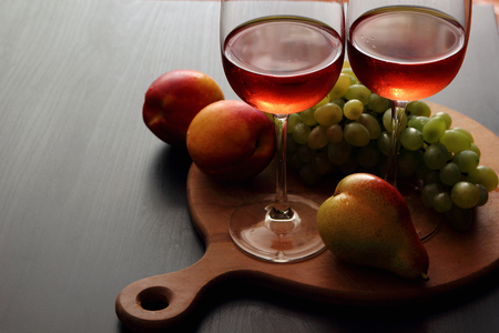 Glasses with pink wine and fruit.
の写真素材
