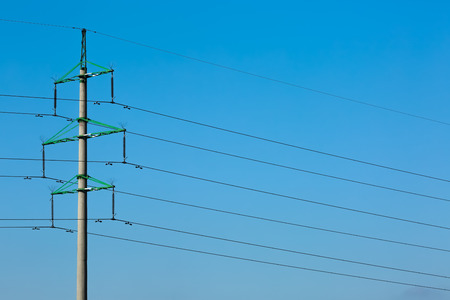 High voltage power lines with electricity pylons at blue sky.の写真素材