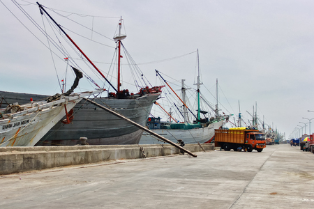 Phinisi ship in a harbor with trucks at the background in Jakarta, Indonesia.のeditorial素材