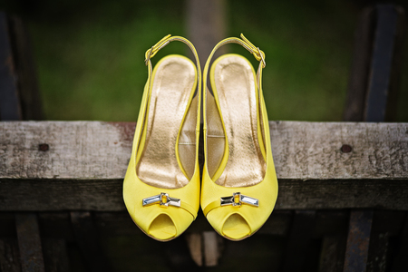 Yellow female satin open toe pumps detail. Photo is taken outdoor in rustical setting.の写真素材
