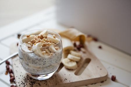 Banana chia yogurt pudding decorated with ripe sliced banana and peanutsの写真素材