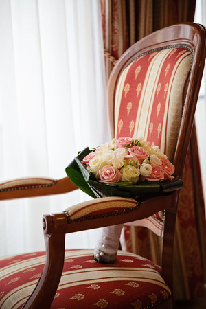 Photo taken in the Arcadia hotel room, detail shot of wedding bouquet placed on the padded chairの写真素材