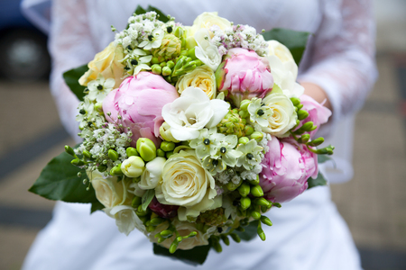 Bride holding a wedding bouquet, selective focus, close-up.の写真素材