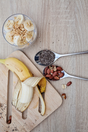 Banana chia yogurt pudding decorated with ripe sliced banana and peanutsの写真素材