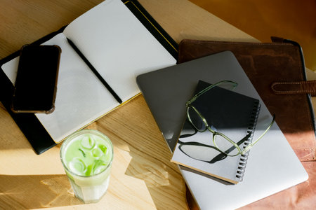 Serene workspace with matcha drink and notebook.の写真素材