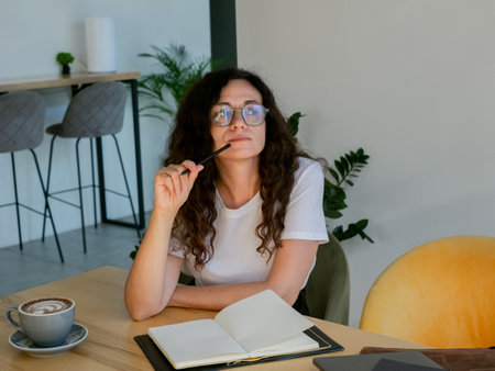 Focused woman jotting down notes in workspace