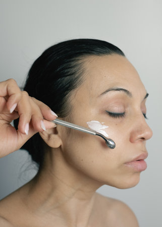 Woman using facial massage toolの写真素材
