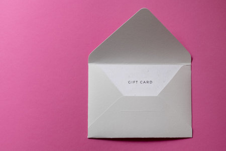 Stylish gift certificate with gray envelope on pinkの写真素材