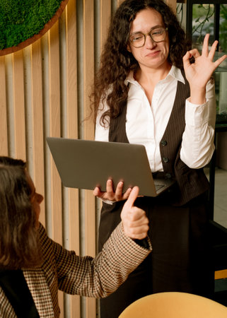 Women celebrating their work with okay signs and okay with thumb up