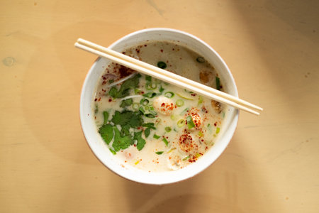 Bowl of Asian coconut milk soup on a tableの写真素材