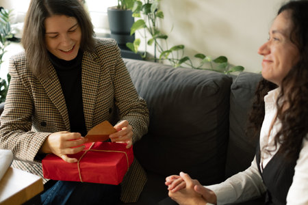 Smiling woman receiving a gift from her friend
