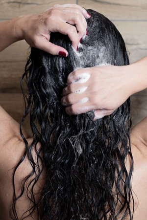 Rinsing curly hair with shampooの写真素材