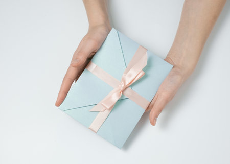 Hand holding blue gift envelopeの写真素材