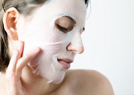 Womanâs face wearing a collagen sheet maskの写真素材