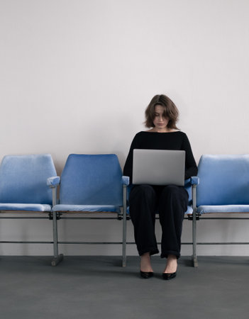 Businesswoman sitting on bench with laptopの写真素材