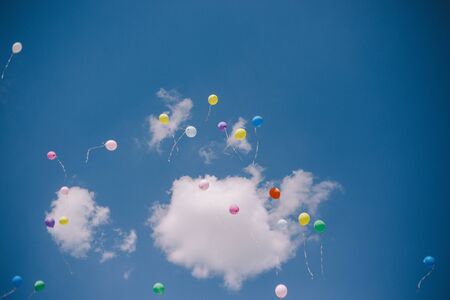 Multicolored balloons against the blue sky and clouds. Last call and graduation at schoolの写真素材