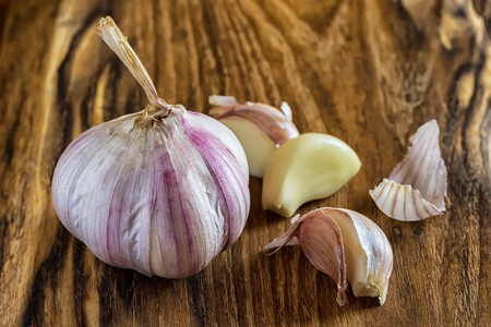 Garlic on Wooden Vintage Background. Fresh Garlic Bulb with Garlic Cloves on Chopping Board.の写真素材