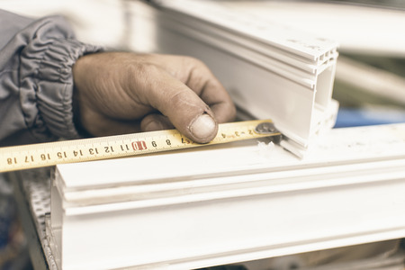 Worker Manufacture Window. Injured Hands From Manual Work and Meter. Plastic Window and Door Industry Production.の写真素材