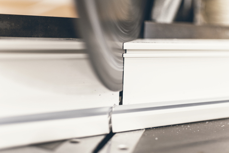 Circular Saw Cutting PVC Profile Close Up. Plastic Window and Door Industry Production.の写真素材