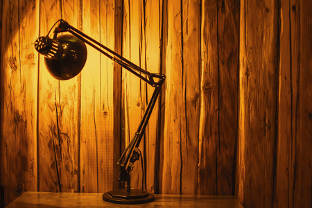 Table Top Lamp Lit Over a Wooden Textured Background. Copy Space.の写真素材