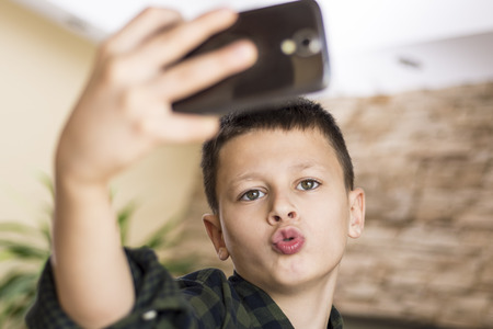 Funny Boy Taking Comic Selfie with Weird Expressionの写真素材